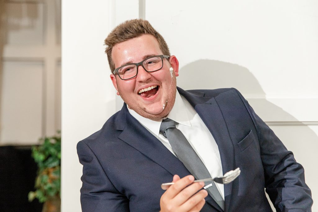 photos of the groom laughing with cake on his face.