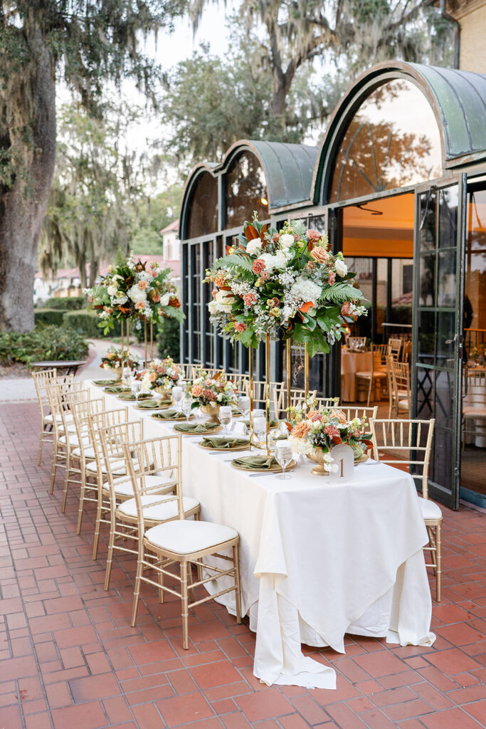wedding reception table with white tablecloth and white and pink floral arrangements outside of Epping Forest Yacht Club wedding venue in Jacksonville, Florida, captured by Snapshots by Gabriela