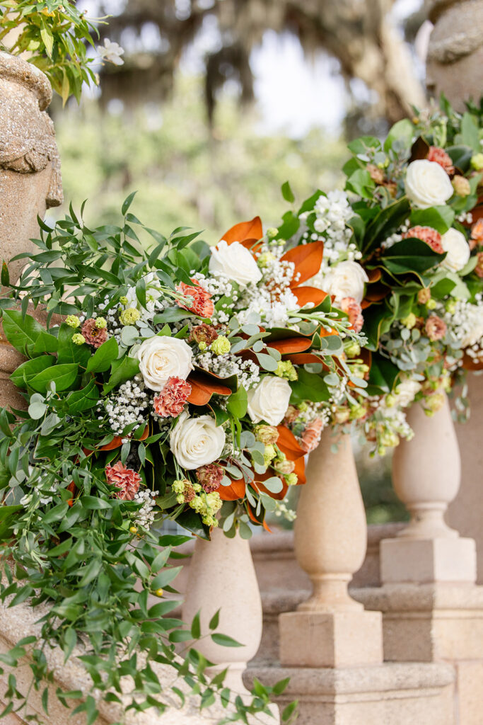 white, green, and burnt orange floral arrangement on stone staircase at Epping Forest Yacht Club in Jacksonville, Florida, captured by Snapshots by Gabriela