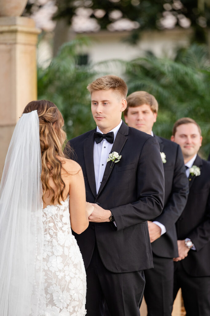 bride and groom hold hands during an outdoor wedding ceremony at Epping Forest Yacht Club in Jacksonville, Florida, captured by Snapshots by Gabriela