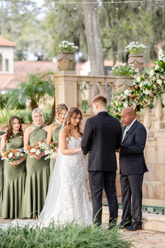 bride and groom hold hands during an outdoor wedding ceremony at Epping Forest Yacht Club in Jacksonville, Florida, captured by Snapshots by Gabriela