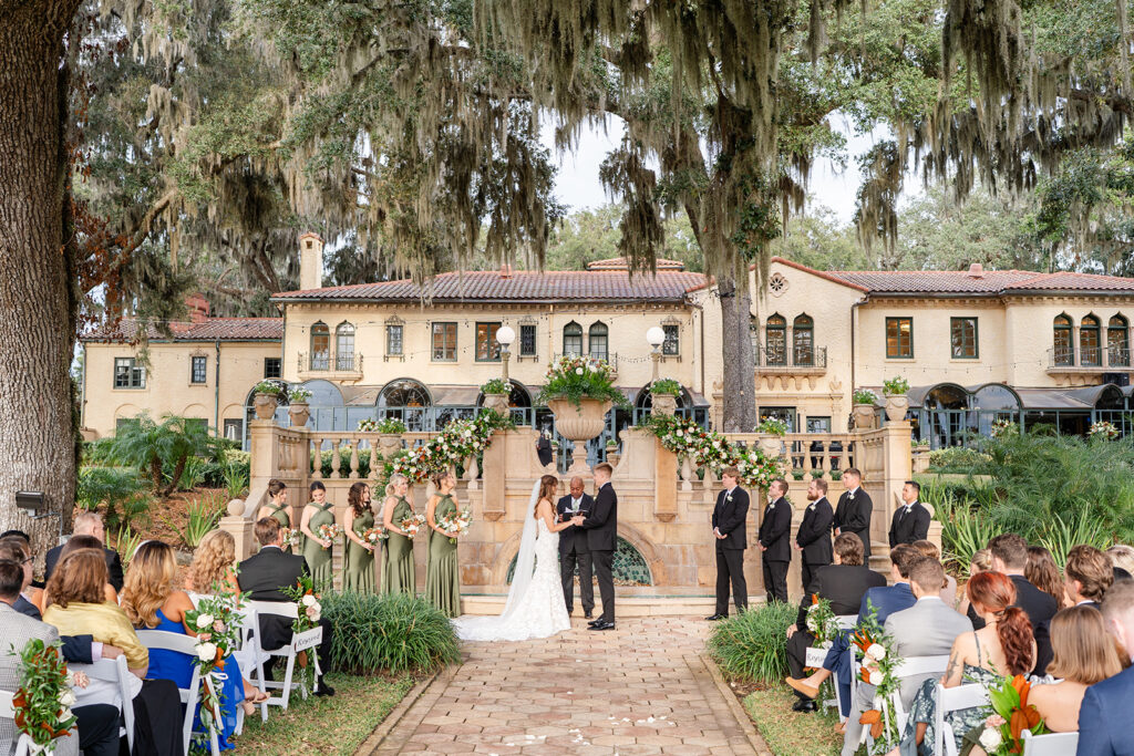bride and groom hold hands during an outdoor wedding ceremony at Epping Forest Yacht Club in Jacksonville, Florida, captured by Snapshots by Gabriela