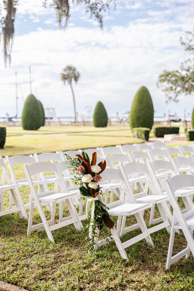 Outdoor ceremony setup on the lawn with white chairs at Epping Forest Yacht Club in Jacksonville, Florida, captured by Snapshots by Gabriela