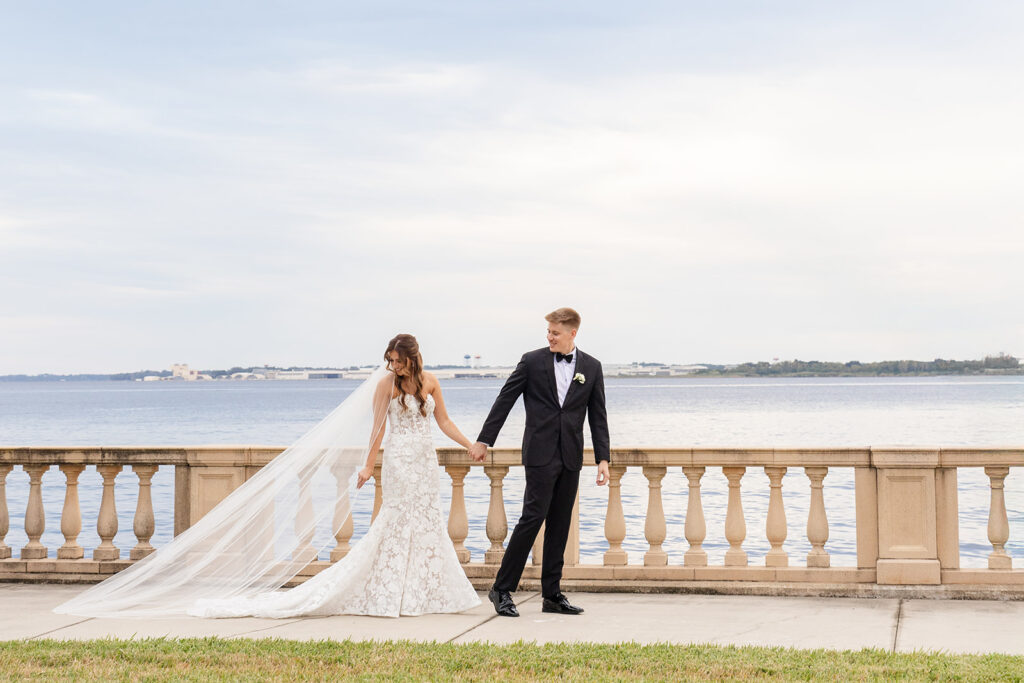 bride and groom posing in front of a river at Epping Forest Yacht Club in Jacksonville, Florida, captured by Snapshots by Gabriela