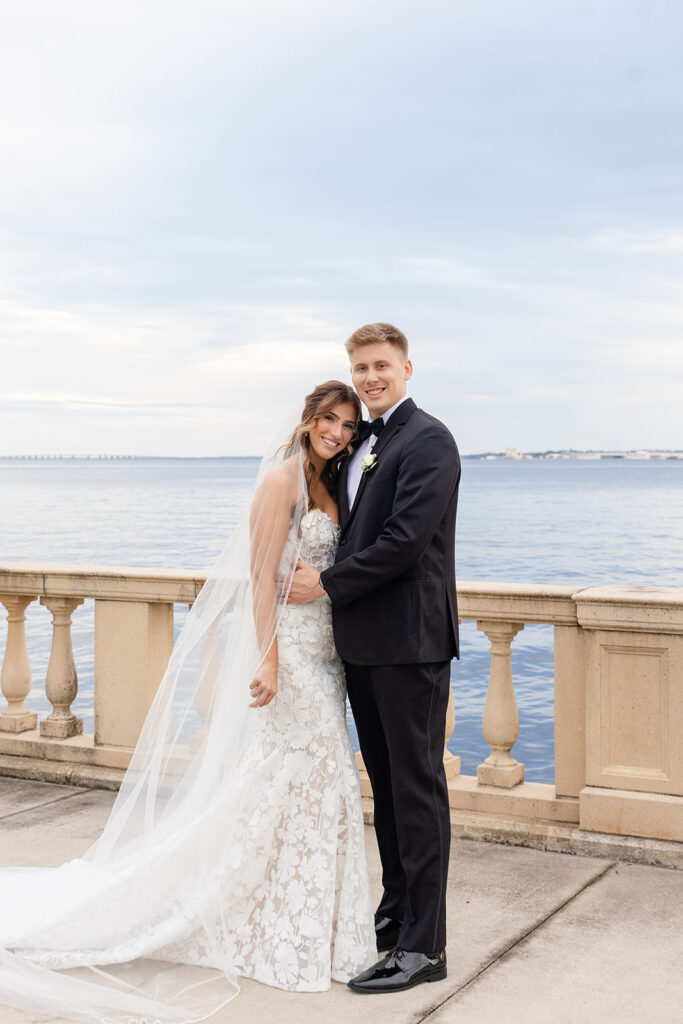 bride and groom posing in front of a river at Epping Forest Yacht Club in Jacksonville, Florida, captured by Snapshots by Gabriela