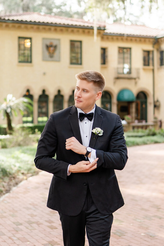 groom portrait in black tuxedo in front of the outdoor stone staircase at Epping Forest Yacht Club in Jacksonville, Florida, captured by Snapshots by Gabriela