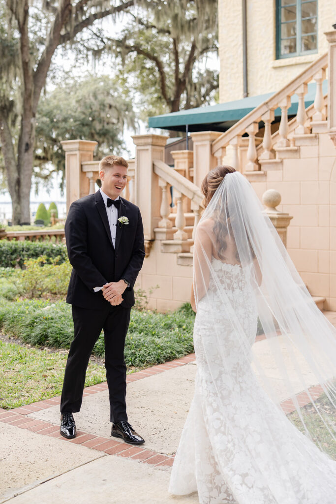 bride and groom first look in front of the outdoor staircase at Epping Forest Yacht Club in Jacksonville, Florida, captured by Snapshots by Gabriela
