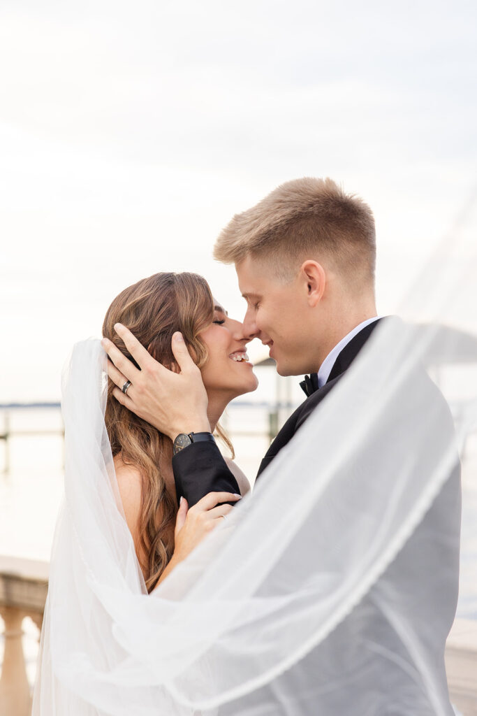 bride and groom posing in front of a river at Epping Forest Yacht Club in Jacksonville, Florida, captured by Snapshots by Gabriela