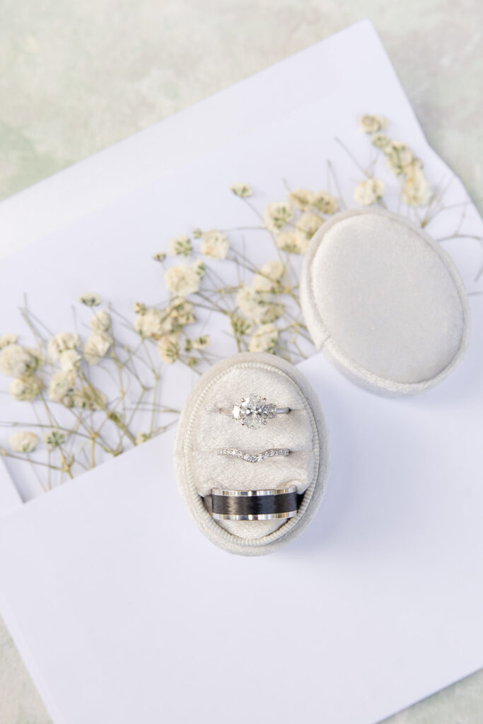 white oval ring box on top of baby's breath