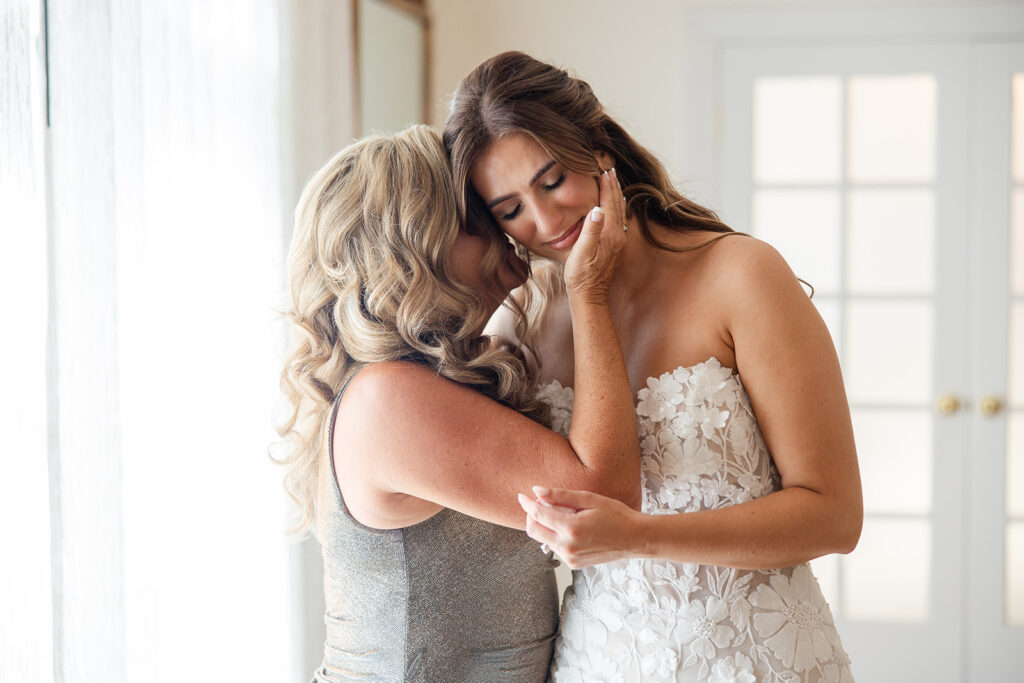 bride in lace dress embraced by her mother at Epping Forest Yacht Club in Jacksonville, Florida, captured by Snapshots by Gabriela