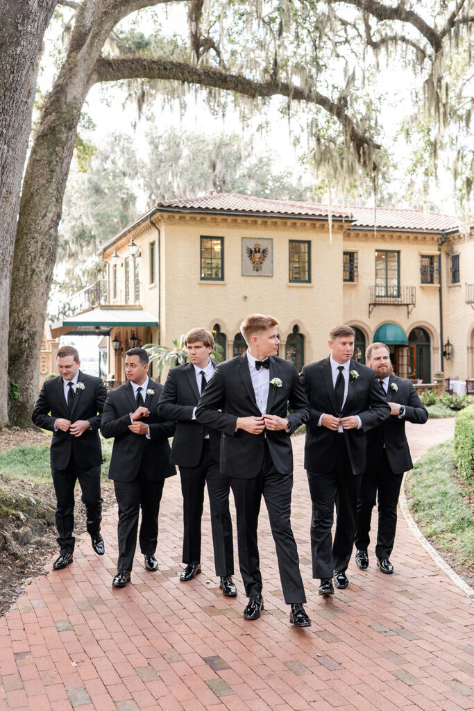 Wedding party portrait with groomsmen and groom wearing black tuxedos at Epping Forest Yacht Club in Jacksonville, Florida, captured by Snapshots by Gabriela