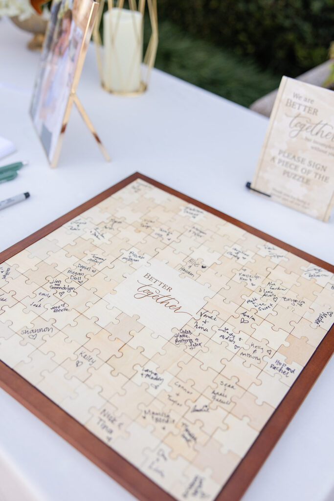 wooden puzzle guestbook with signatures at an outdoor wedding reception at Epping Forest Yacht Club in Jacksonville, Florida, captured by Snapshots by Gabriela
