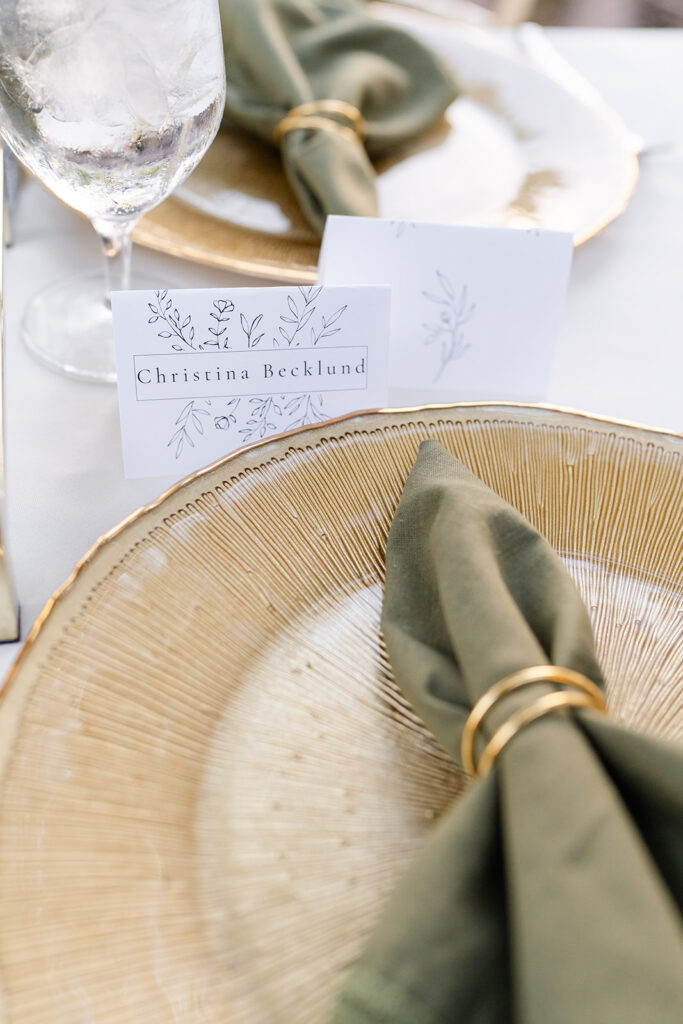 green napkin on a gold charger at an outdoor wedding reception at Epping Forest Yacht Club in Jacksonville, Florida, captured by Snapshots by Gabriela
