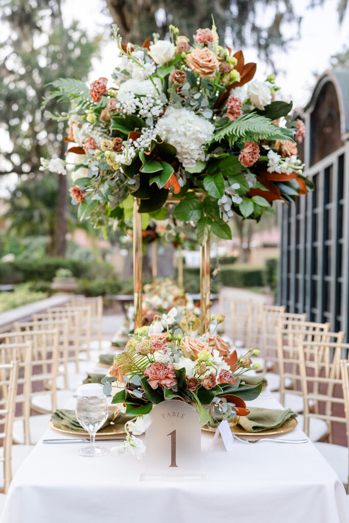 long reception table with fall florals and gold chiavari chairs at an outdoor wedding reception at Epping Forest Yacht Club in Jacksonville, Florida, captured by Snapshots by Gabriela