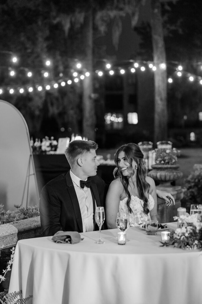bride and groom seated at sweetheart table at an outdoor wedding reception at Epping Forest Yacht Club in Jacksonville, Florida, captured by Snapshots by Gabriela