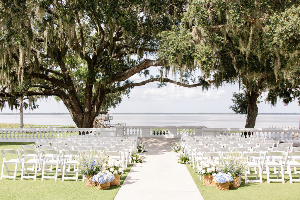 outdoor ceremy setup with white folding chairs on the lawn at Bella Cosa Lakeside in Lake Wales Florida