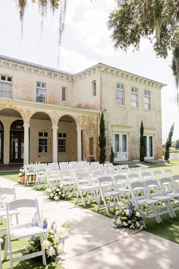 outdoor ceremy setup with white folding chairs on the lawn at Bella Cosa Lakeside in Lake Wales Florida