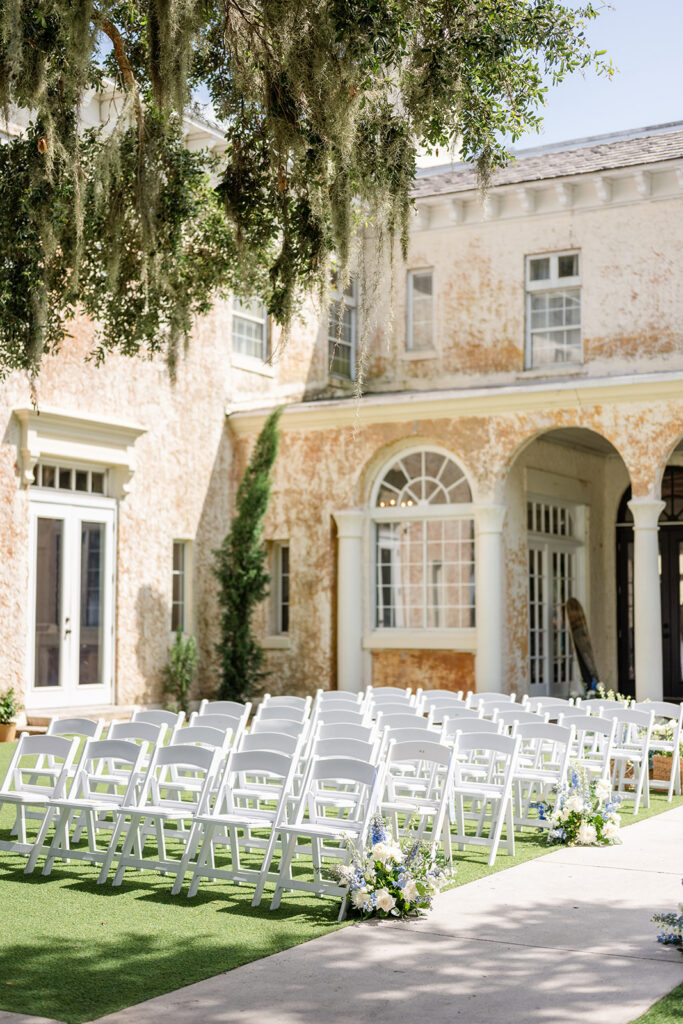 outdoor ceremy setup with white folding chairs on the lawn at Bella Cosa Lakeside in Lake Wales Florida