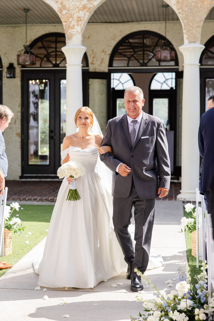bride walking down the aisle at an outdoor wedding ceremony on the lawn at Bella Cosa Lakeside in Lake Wales Florida
