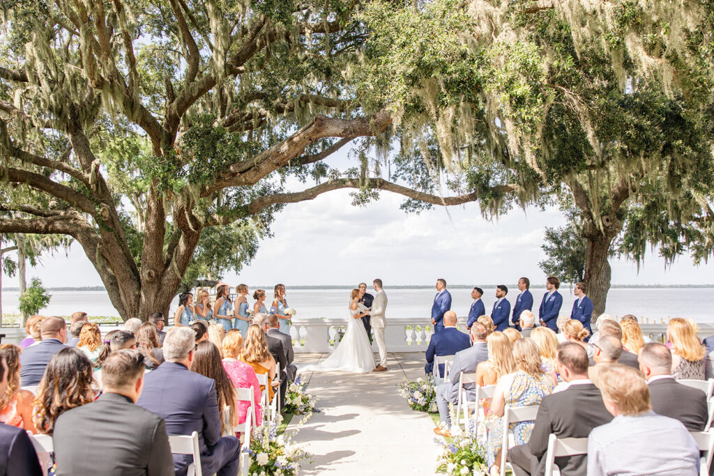 bride and groom under mossy trees at their outdoor wedding ceremony on the lawn at Bella Cosa Lakeside in Lake Wales Florida