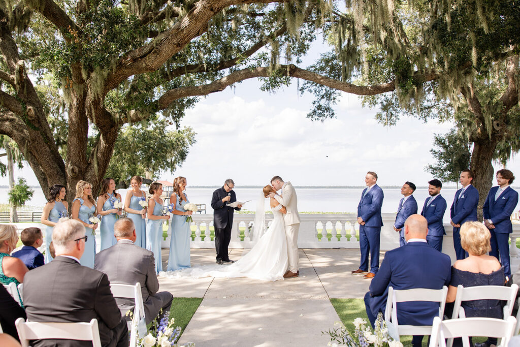 bride and groom under mossy trees at their outdoor wedding ceremony on the lawn at Bella Cosa Lakeside in Lake Wales Florida