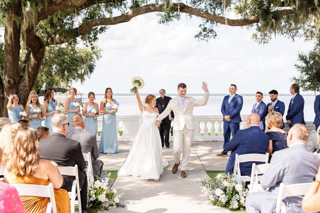 bride and groom under mossy trees at their outdoor wedding ceremony on the lawn at Bella Cosa Lakeside in Lake Wales Florida