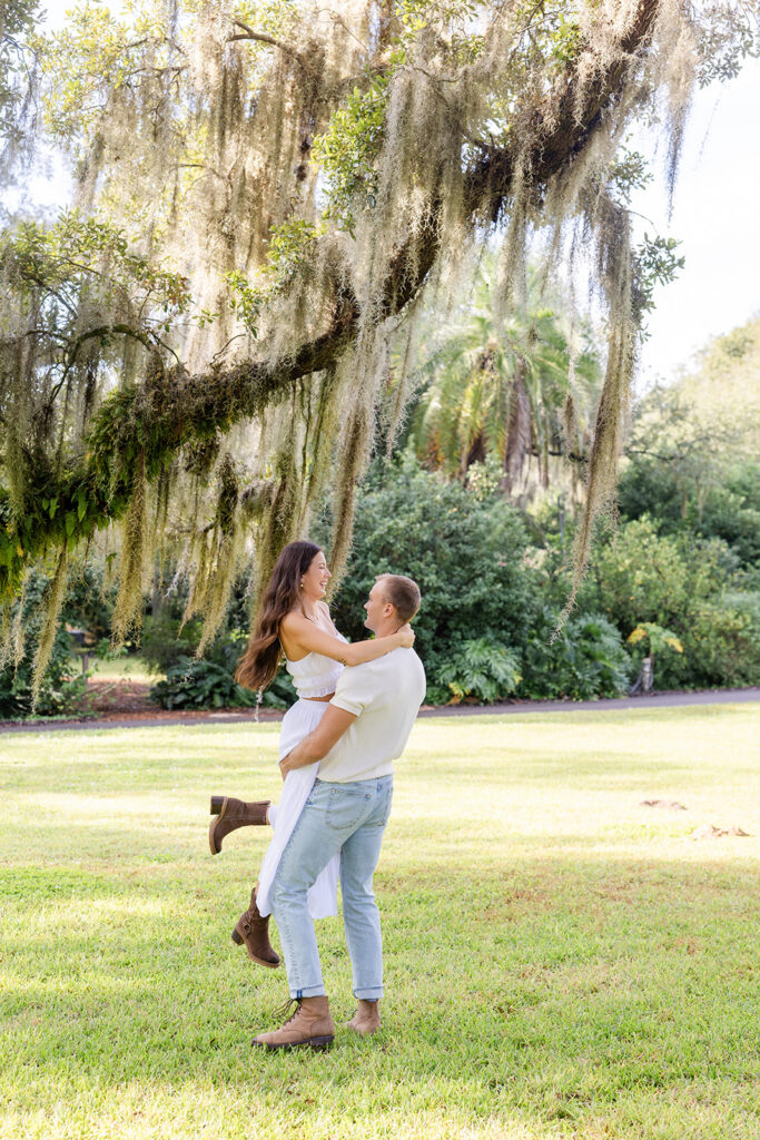 couple dances and twirls in a casual engagement photo at Bok Tower Gardens captured by Snapshots by Gabriela.