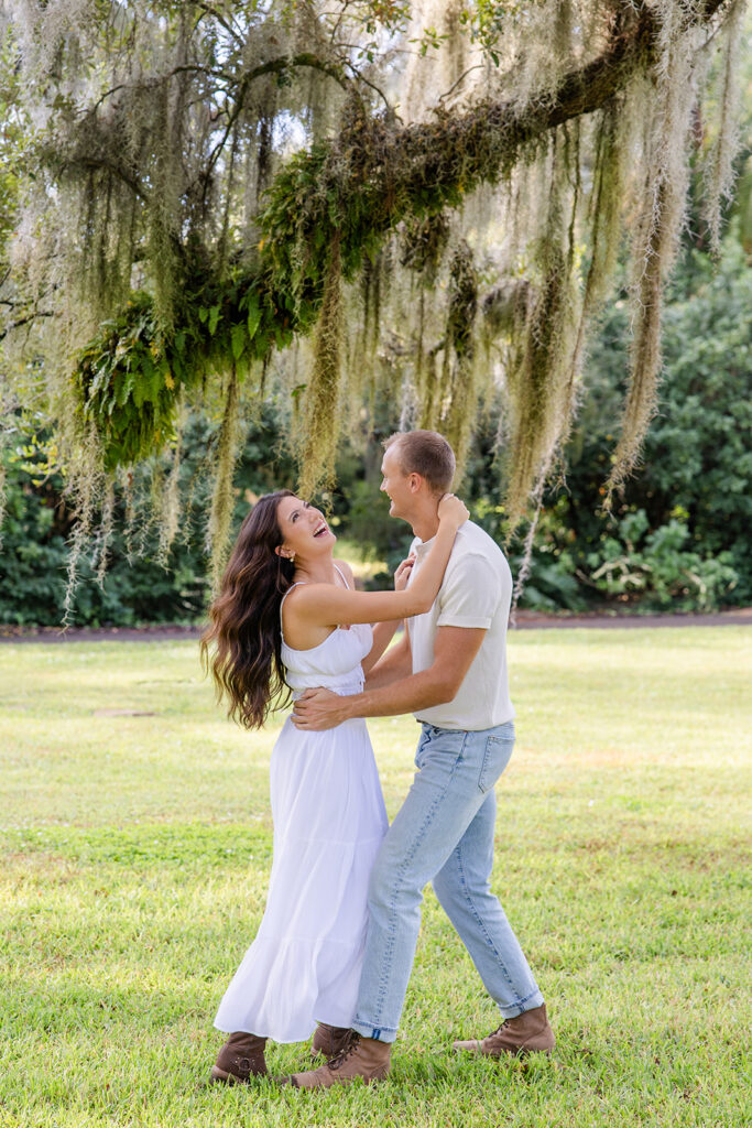 couple dances and twirls in a casual engagement photo at Bok Tower Gardens captured by Snapshots by Gabriela.