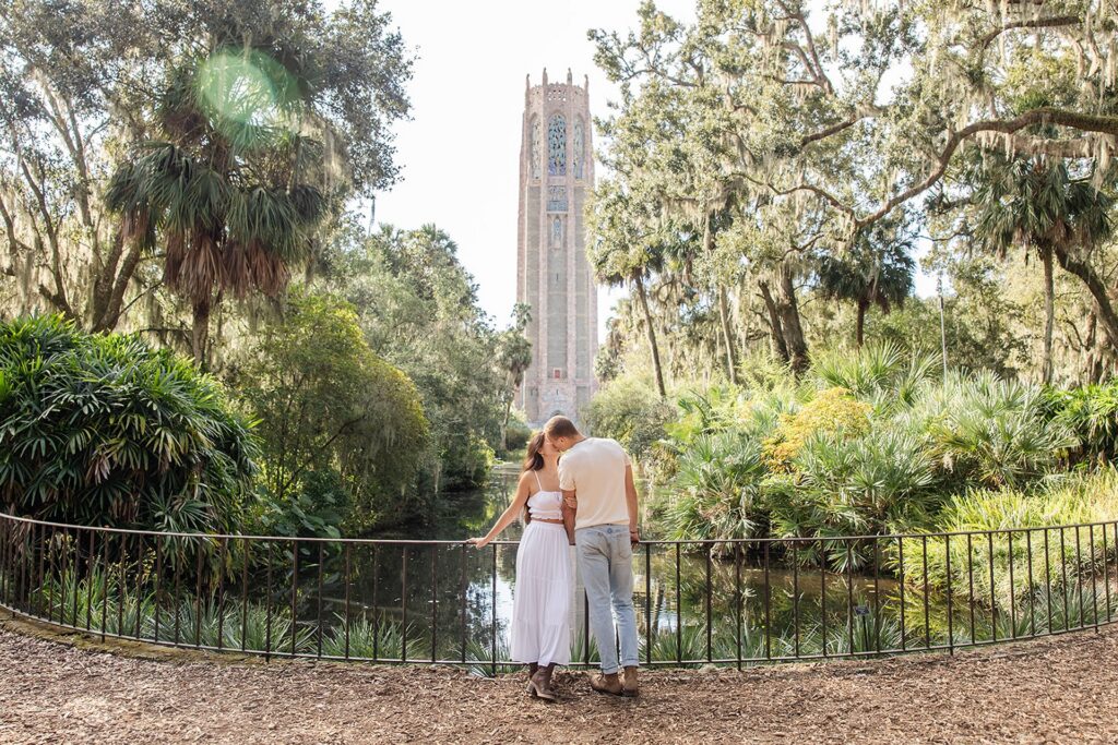 Couple stands in front of the Singing Tower in a casual engagement photo at Bok Tower Gardens captured by Snapshots by Gabriela.