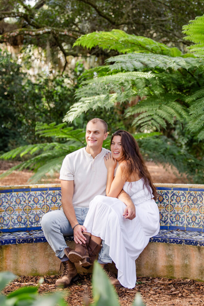 couple sits and laughs in a casual engagement photo at Bok Tower Gardens captured by Snapshots by Gabriela.