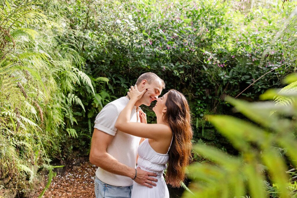 couple embraces on a nature path in a casual engagement photo at Bok Tower Gardens captured by Snapshots by Gabriela.