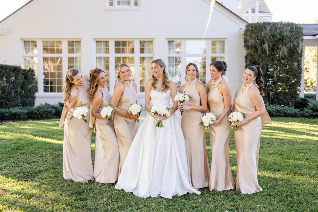 bride with bridesmaids in champagne dresses at an outdoor wedding at Adams Estate in Lake Alfred, Florida, captured by Snapshots by Gabriela