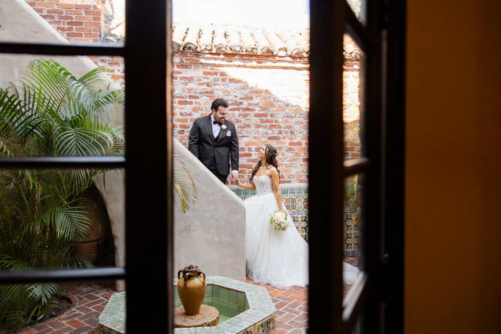 bride and groom stand in the Spanish courtyard during their first look at their wedding at Casa Feliz in Winter Park, Florida, photographed by Snapshots by Gabriela