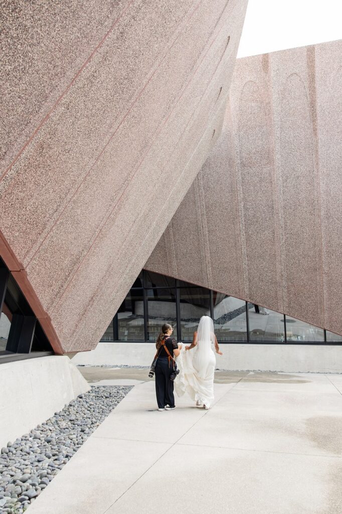 a behind-the-scenes photo of Gabriela from Snapshots by Gabriela, an Orlando wedding photographer, walking with a bride and talking with her on wedding day