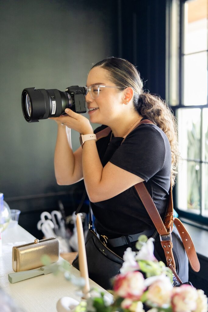 a behind-the-scenes photo of Gabriela from Snapshots by Gabriela, an Orlando wedding photographer, taking a photo on a wedding day