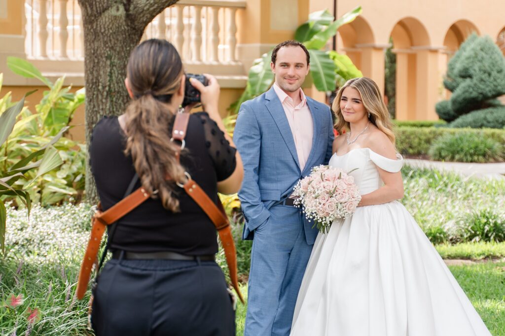 a behind-the-scenes photo of Gabriela from Snapshots by Gabriela, an Orlando wedding photographer, capturing a bride and groom on their wedding day