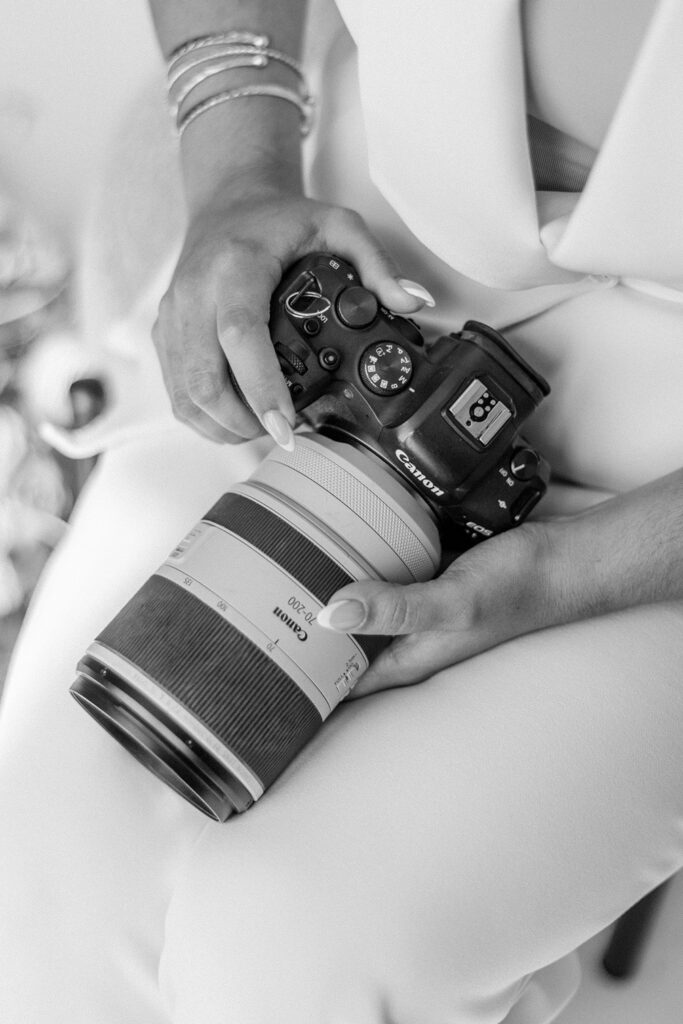 black-and-white photo of Gabriela from Snapshots by Gabriela, an Orlando wedding photographer, with her camera on her lap