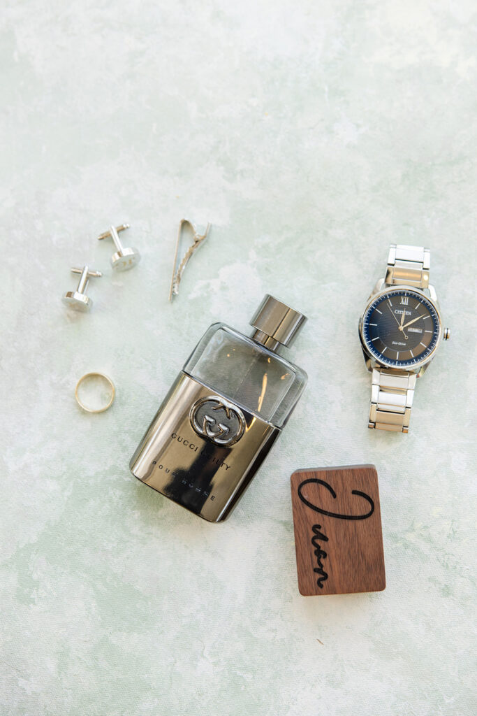 groom details shot with cologne, watch, and cufflinks