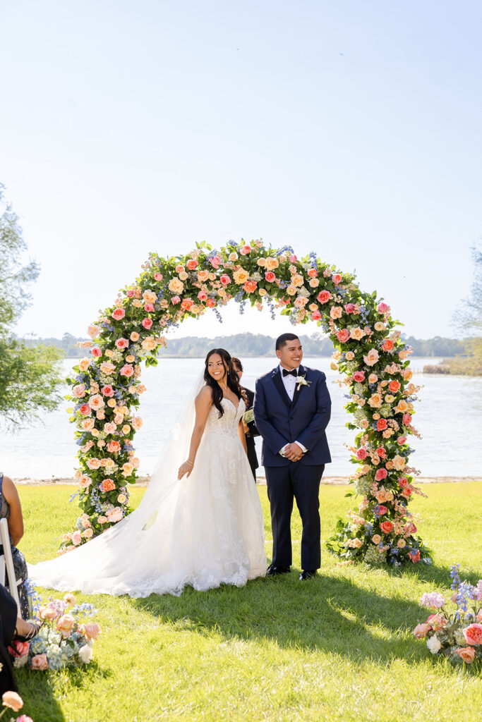 bride and groom under a floral arch at a spring wedding at Lake Mary Events Center, captured by Snapshots by Gabriela