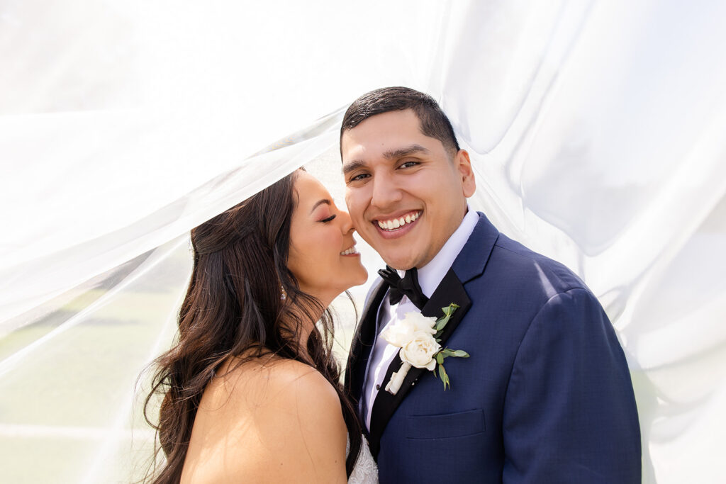 bride and groom outdoor portrait under bride's veil at a spring wedding at Lake Mary Events Center, captured by Snapshots by Gabriela