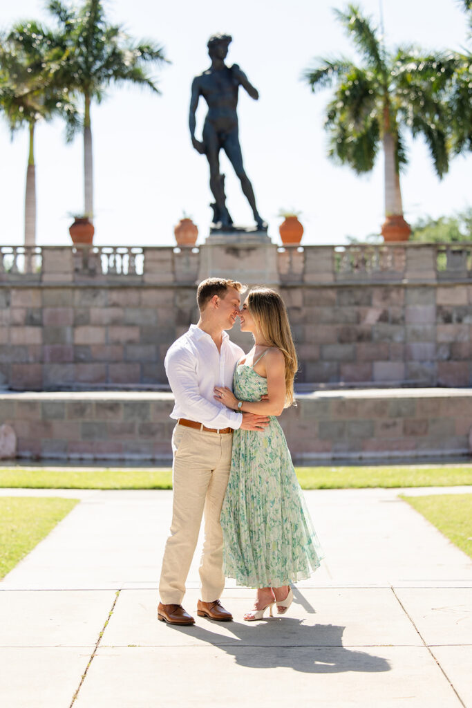 Woman in green floral dress and man in white shirt and khaki pants at The Ringling Museum in Sarasota for their engagement photos captured by Snapshots by Gabriela