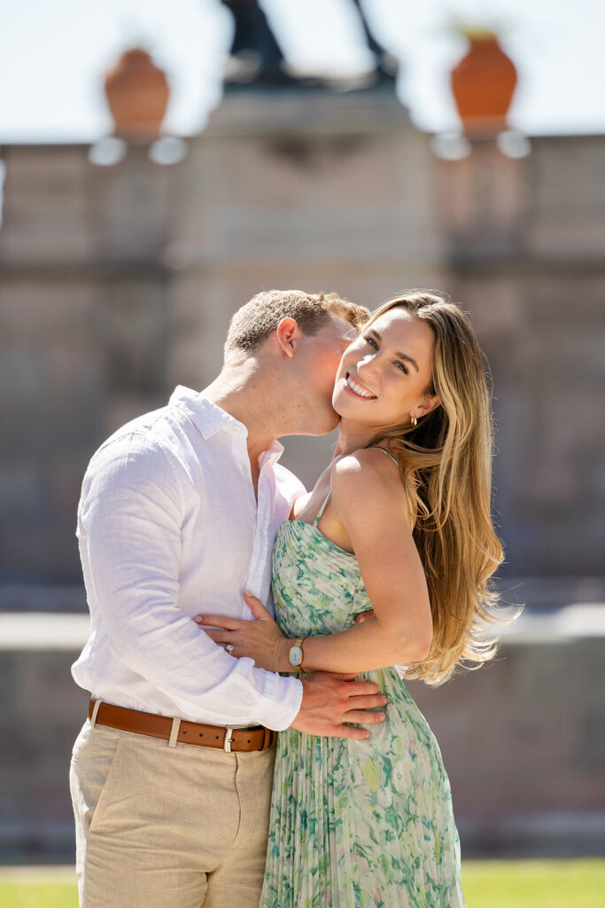 Woman in green floral dress and man in white shirt and khaki pants at The Ringling Museum in Sarasota for their engagement photos captured by Snapshots by Gabriela
